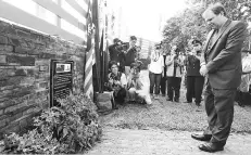  ??  ?? Subritzky observes a moment of silence after laying a wreath at the newly-installed commemorat­ive plaque.