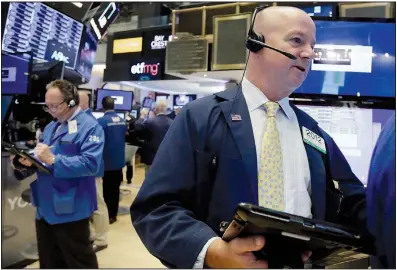  ?? AP/RICHARD DREW ?? Trader Patrick Casey (right) works on the floor of the New York Stock Exchange on Monday. U.S. stocks rose and Mexico’s peso rallied against the dollar as the Trump administra­tion announced a tentative bilateral trade deal with Mexico.