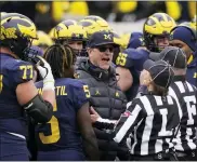  ?? CARLOS OSORIO — THE ASSOCIATED PRESS ?? Referees talk to Michigan head coach Jim Harbaugh during the second half of a college football game against Ohio State on Saturday in Ann Arbor.