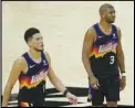  ?? Associated Press ?? TEAMMATES — Phoenix Suns guards Devin Booker (left) and Chris Paul (3) walk on the court during the second half of Game 5 of the NBA Finals against the Milwaukee Bucks on Saturday in Phoenix.