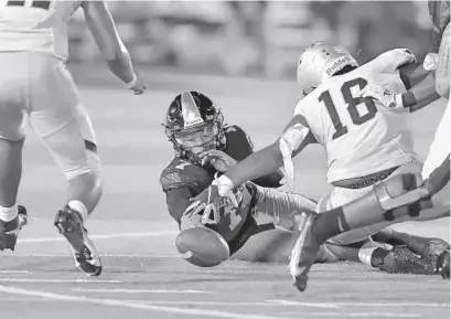  ?? MICHAEL LAUGHLIN/SUN SENTINEL PHOTOS ?? American Heritage quarterbac­k Blake Murchy fumbles the ball Friday against St. Thomas Aquinas.