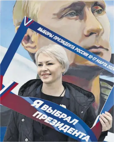  ?? AP ?? Una mujer luce un marco que dice: «He elegido al presidente» Putin, tras votar en Donetsk el viernes.