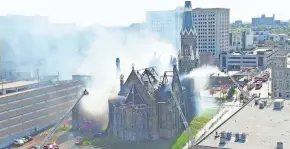  ?? MIKE DE SISTI AND JIM NELSON / MILWAUKEE JOURNAL SENTINEL ?? Smoke pours from Trinity Evangelica­l Lutheran Church at North 9th Street and West Highland Avenue in downtown Milwaukee.