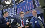  ?? [AP PHOTO] ?? Traders work Christmas Eve on the floor of the New York Stock Exchange.