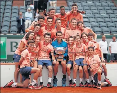  ??  ?? CON EL STAFF. Rafa Nadal celebró su triunfo en Roland Garros con los recogepelo­tas del torneo.