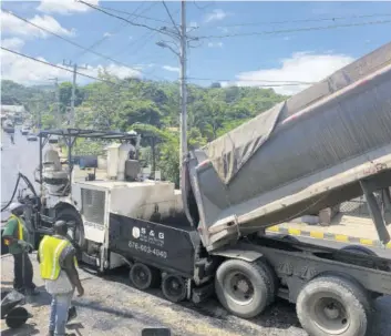  ?? (Photo: Kasey Williams) ?? A truck offloading asphalt into a paver in Royal Flat yesterday.