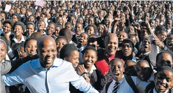  ?? Picture: BHONGO JACOB ?? MAKING A DIFFERENCE: Businessme­n and Silulo Ulutho Technologi­es owners, from left, Luvuyo Rani and his brother Lonwabo, surrounded by KwaKomani Comprehens­ive High School pupils on Tuesday