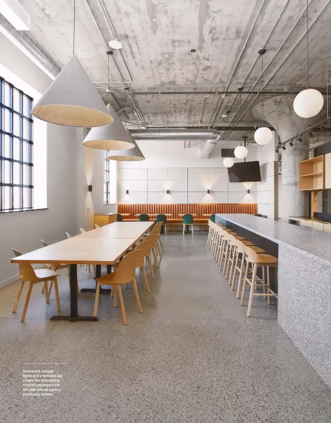  ??  ?? Oversized conical lights and a terrazzo bar create the welcoming kind of lunchroom the 60-year-old ad agency previously lacked.