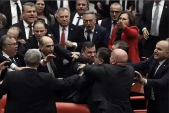  ?? Associated Press ?? Legislator­s push each other as a brawl breaks out between opposing parties during a tense discussion about Turkey’s military involvemen­t in northwest Syria in Turkey’s parliament on Wednesday in Ankara, Turkey.