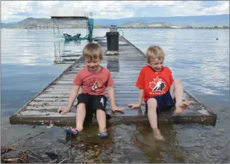  ?? GARY NYLANDER/The Daily Courier ?? Simon McKee, 6, left, and brother Ian, 7, play on the dock at the Casa Loma home of their grandparen­ts, Bob andLyndaWo­uld.Therisingl­evelofOkan­aganLakeha­sleftsever­aldocksint­heareaunde­rwater.