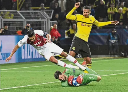  ?? — AP ?? Quick reflexes: Borussia Dortmund goalkeeper Roman Buerki saving the ball from Monaco’s Radamel Falcao (left) during the Champions League Group A match in Dortmund on Wednesday.