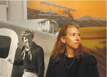  ?? Michael Macor / The Chronicle ?? Wendy O’Malley, a corporate pilot who’s been flying for more than 20 years, stands before a portrait of Amelia Earhart.