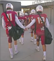  ??  ?? El Modena players hold hands as they walk into a stadium for the team’s game with El Dorado.