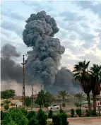  ?? AP ?? DANGEROUS MOMENT: Plumes of smoke rise after an explosion at a military base southwest of Baghdad on Monday. Iraq is ordering all military camps and munitions warehouses to be moved outside cities following the explosion at an ammunition depot. —