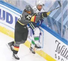  ?? JEFF VINNICK/GETTY IMAGES ?? Vegas Golden Knights winger Ryan Reaves checks Vancouver Canucks defenceman Chris Tanev during Game 1 of their Western Conference second-round series Sunday in Edmonton.