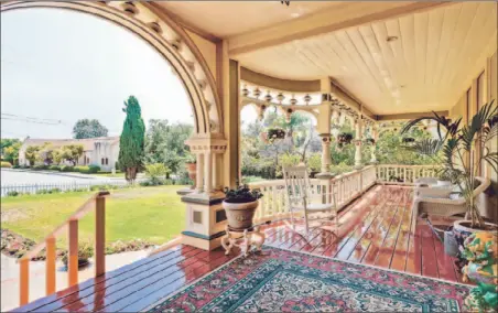  ?? Photograph­s by Erik Grammer ?? A VERANDA looks out across the front yard of the 10,000-square-foot home, which sits on nearly half an acre of land.