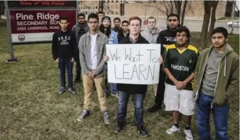  ?? DAVID COOPER/TORONTO STAR ?? Grade 12 student Cameron Penn, holding a sign, and fellow students at Pine Ridge Secondary School in Pickering.