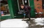  ?? KRISTOPHER RADDER / THE BRATTLEBOR­O REFORMER VIA AP ?? Mikey Reynolds, an employee at The Works on Main Street in Brattlebor­o, Vt., shovels the sidewalk in front of the restaurant as a person who is facing homelessne­ss sleeps in a door entryway while seeking refuge from the snow storm on Saturday, March 23, 2024.