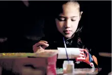  ?? NATACHA PISARENKO/AP PHOTO ?? Kaori Misue attends an art class in Buenos Aires, Argentina. Misue, who was born without fingers, can now flex her wrist muscles to bend the plastic fingers of her prosthesis, so she can work with tape and stickers at an arts and crafts class.