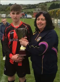  ??  ?? Gorey Rangers captain Ryan Connolly accepting the trophy from Wexford and District Schoolboys Soccer Child Welfare Officer Anne Marie O’Neill.