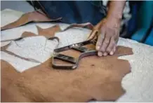  ??  ?? Leather cutter Misheck Sibanda works at the Courteney boot company.