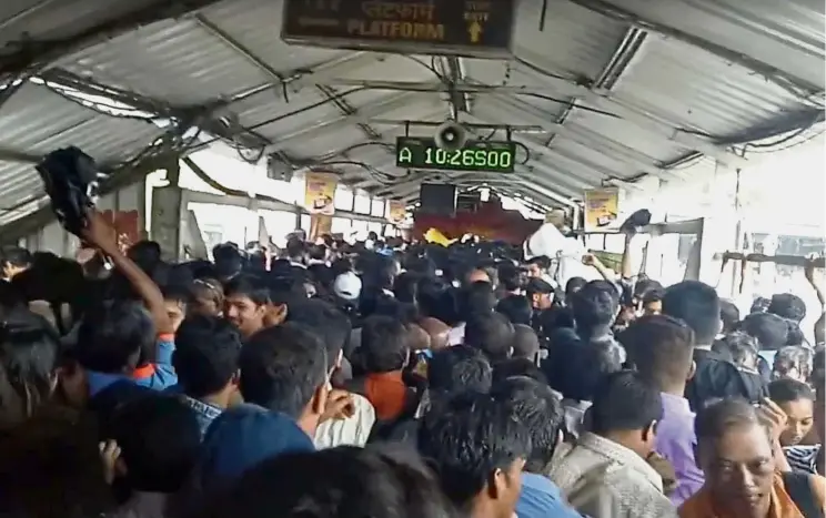  ??  ?? Squeezed in: Crowds of commuters moving along the Elphinston­e railway station bridge around the time of the stampede in this still image taken from a social media video. — Reuters