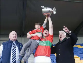  ??  ?? Rathnew captain Charlie Cruse holds the cup and Shay Melia aloft as Pat Mitchell and Pat Dunne look on.