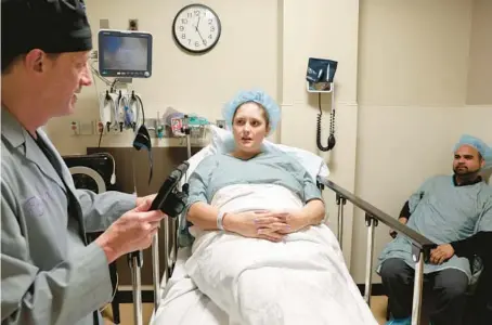  ?? ANTONIO PEREZ/CHICAGO TRIBUNE ?? Dr. Randy Morris, left, talks with patient Ashley Kawash and her husband, Ashraf Kawash, before a procedure at the Naperville Fertility Center on Wednesday.