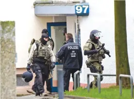  ??  ?? CHEMNITZ, GERMANY: Police officers leave an apartment after detonation­s in the eastern city on Saturday. —AP