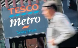  ?? AFP ?? A man walks past a Tesco Metro store in central London.