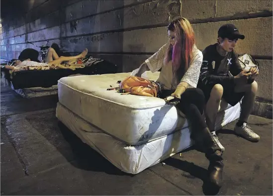  ?? Photograph­s by Carolyn Cole Los Angeles Times ?? JUSTIN SMITH and his girlfriend, Christina Gambrill, both heroin addicts, sleep under a bridge in Philadelph­ia. Smith says he became addicted to pain pills after a car accident. Gambrill isn’t paying attention to politics. “I can’t worry about America...