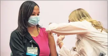  ?? Joseph Prezioso / AFP via Getty Images / TNS ?? Pharmacist Madeline Acquilano inoculates Lynette Rodriguez with the Johnson & Johnson COVID-19 vaccine at Hartford Hospital on March 3. Officials report an increase in hospitaliz­ed cases.