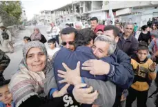  ?? — Reuters ?? Relatives hug one of the hostages held by IS militants who escaped from his captors in Qaryatayn town in Homs province, Syria, on Monday.