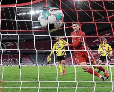  ?? Foto: dpa ?? Der Weltfußbal­ler schlägt zu: Bayern-Stürmer Robert Lewandowsk­i trifft zum 1:2, die Dortmunder Emre Can und Thomas Meunier (r.) können nur zuschauen.