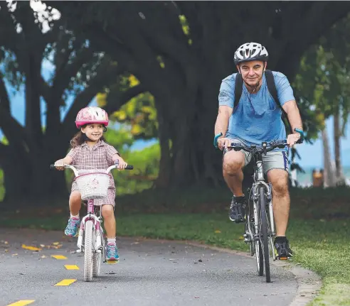  ?? Picture: BRENDAN RADKE ?? DELIGHTFUL EXPERIENCE: (From left) Nina Decavalla, 6, rides along the Cairns Esplanade with her father Chris Decavalla, a route that is perfect for all riders, no matter how old they are or how confident they feel on a bike.