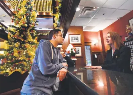  ??  ?? Lee and Desiree Mottard, a couple from Boston, check in at Boulder’s historic Hotel Boulderado last week with assistance from guest services agent Riley Branch. The Hotel Boulderado debuted on New Year’s Day in 1909. Jeremy Papasso, Daily Camera