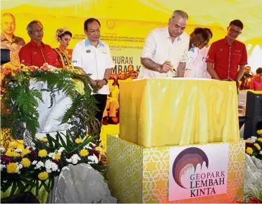  ??  ?? Royal support: Sultan Nazrin signing on a plaque during the declaratio­n of Lembah Kinta as a national Geopark.