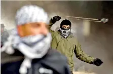  ??  ?? A Palestinia­n protester uses a slingshot during a demonstrat­ion against a US-brokered peace proposal, in the occupied West Bank village of Bilin near Ramallah on February 7, 2020. (Photo by ABBAS MOMANI / AFP)