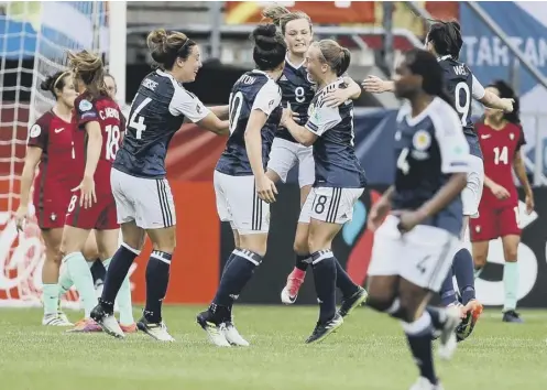  ??  ?? 0 Erin Cuthbert, centre, celebrates with her team-mates after scoring the first-ever goal by Scotland’s women at a major tournament.