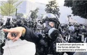  ??  ?? A policeman gestures as the forces detain the pro-democracy protesters