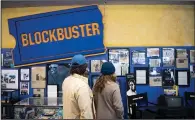  ?? (For The Washington Post/Isaac Wasserman) ?? Ben and Shannon Kapp, who were visiting from Olympia, Wash., admire the memorabili­a at the last Blockbuste­r. “A lot of those memories are just walking around the aisles,” said Shannon.