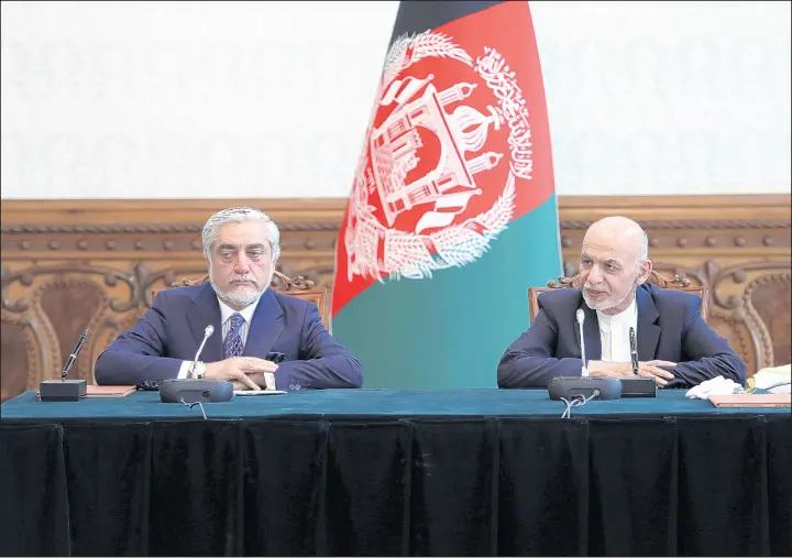  ?? AP ?? Afghan President Ashraf Ghani, right, and political rival Abdullah Abdullah speak after signing a power-sharing agreement May 17 at the presidenti­al palace in Kabul, Afghanista­n.