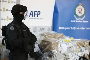  ??  ?? En politibetj­ent bevogter kokain til en vaerdi af ca. 1,7 mia. kr., efter af de australske myndighede­r i december 2016 havde beslagt en historisk stor maengde narko.
Foto: Rick Rycroft/ap