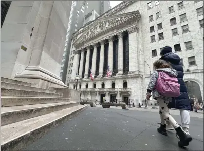  ?? (AP/Peter Morgan) ?? People pass the New York Stock Exchange on Wednesday.