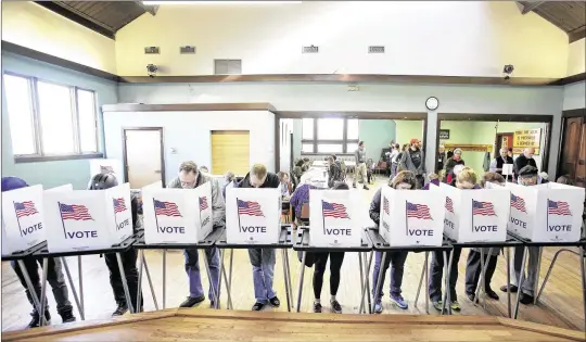  ?? AMBER ARNOLD / WISCONSIN STATE JOURNAL ?? Voters cast their ballots at the Wil-Mar Neighborho­od Center on the Near East Side of Madison, Wisconsin. Five years after Wisconsin passed a strict voter photo ID bill, many voters are prohibited from voting if they lack the required forms of...