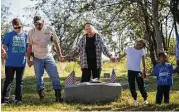  ??  ?? Virginia Morrison joins hands with other members of the community during a prayer of thanks for the veterans and history buried in Byrd Cemetery.