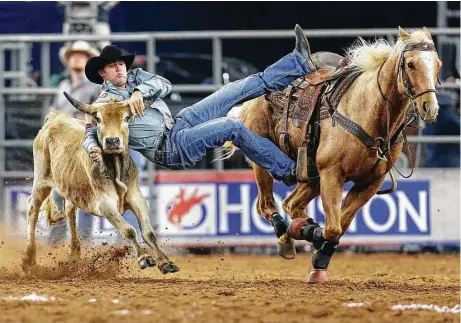  ?? Karen Warren / Houston Chronicle ?? Tyler Waguespack competes during the championsh­ip round of the steer wrestling competitio­n in the Super Series IV at the Houston Livestock Show and Rodeo at NRG Stadium on Saturday. Waguespack came in fourth to clinch a spot in the steer wrestling...