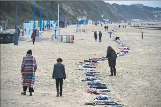  ?? FINNBARR WEBSTER / GETTY IMAGES ?? Clothes representi­ng the 11,500 Palestinia­n children and 36 Israeli children killed in Gaza are on display at the beach in Bournemout­h, England, on Monday.