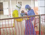  ?? SAMUEL ARANDA / NEW YORK TIMES 2015 ?? Two Doctors Without Borders health workers in Conakry, Guinea, hold an infant infected with the Ebola virus. Each of the 5,837 residents of the African nation who received a new vaccine for the virus in a World Health Organizati­on study last year did...