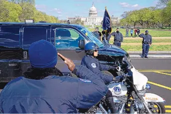  ?? JOSE LUIS MAGANA/ASSOCIATED PRESS ?? With the U.S. Capitol in the background, U.S. Capitol Police officers salute as a procession carries the remains of a U.S. Capitol Police officer who was killed after a man rammed a car into two officers at a barricade outside the Capitol in Washington Friday.